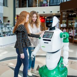 An image showing two girls communicating with humanoid robot.